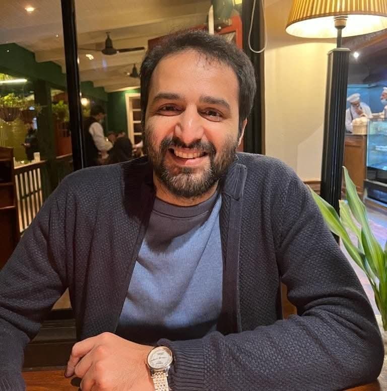 Akram Akbar, the instructor, smiling at a cafe